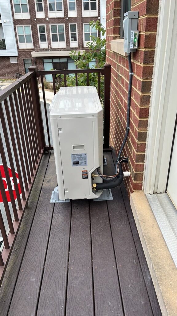 Side view of a new Daikin Fit heat pump on townhome deck