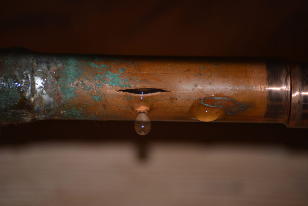 Burst copper water supply pipe dripping water