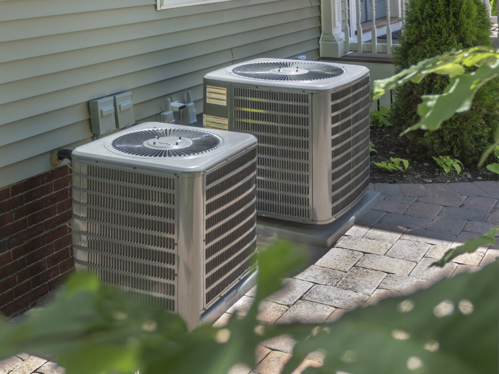 Two air conditioners outside a home