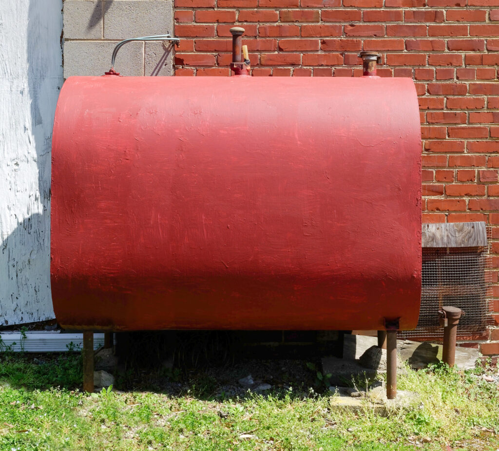 Home heating oil tank for an oil furnace, installed outside a brick home.